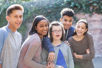 A group of friends standing together, smiling. 