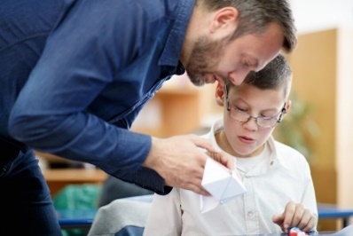 A teacher helping a student with disability.