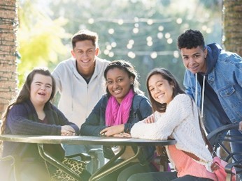 A group of people smiling and laughing at a table. 