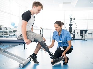 Medical staff fitting a leg prosthetic to a patient.