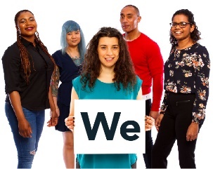 A group of people. There is a woman at the front of the group, she is holding a card that says "we". 