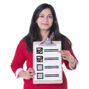 A woman holding a clipboard with some ticked and unticked boxes on it.