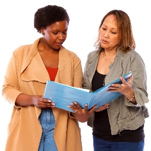 2 women looking at a folder together.