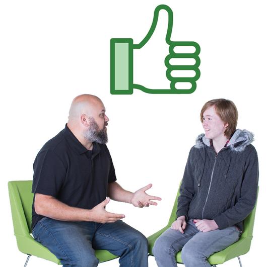 A support worker talking to an Autistic person. There is a thumbs up above them.