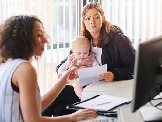 A parent with a young child getting support from a professional.